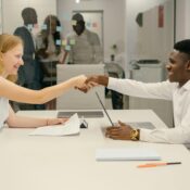 Free Business professionals completing a successful deal with a handshake in a modern office setting. Stock Photo